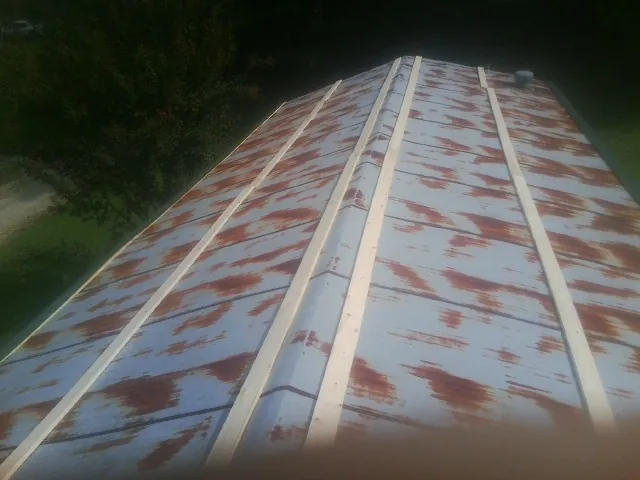 Rusted metal roof panels with new wood purlins before replacement — Storm Damage Roof Repair in Wainscott by Roofing Brothers